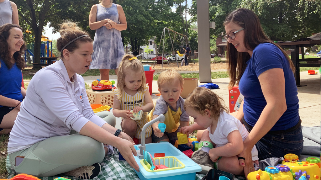children play with a toy sink, cleaning toy dishes